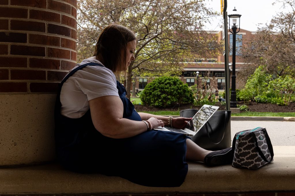 Student looking at laptop on campus.