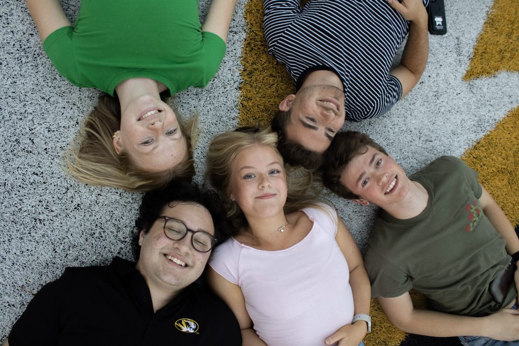 Students taking picture on field.