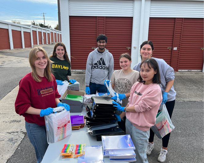 Students helping with books at event.